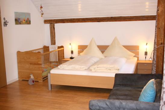 Großes Elternschlafzimmer mit Holzgitterbettchen